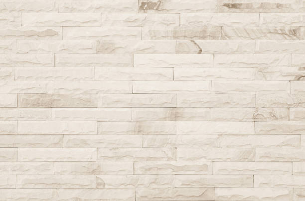 istock Empty background of wide cream brick wall texture. Beige old brown brick wall concrete or stone textured, wallpaper limestone abstract flooring/Grid uneven interior rock. Home decor design backdrop. 1369252808