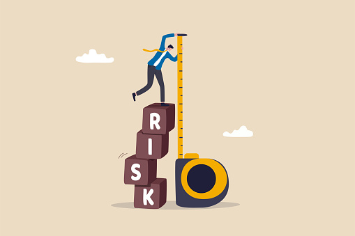 Risk assessment, analyze potential danger level, measure money loss acceptable for investing, control or limit loss concept, businessman investor stand on stack of risk boxes measure his assessment.