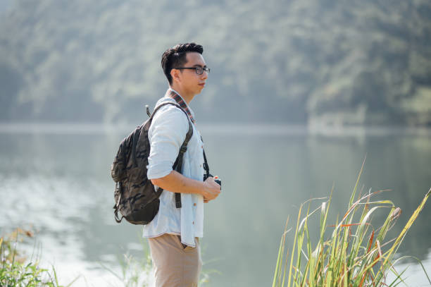 istock Hiker with a backpack watching the lake surrounding by mountains 1369261782