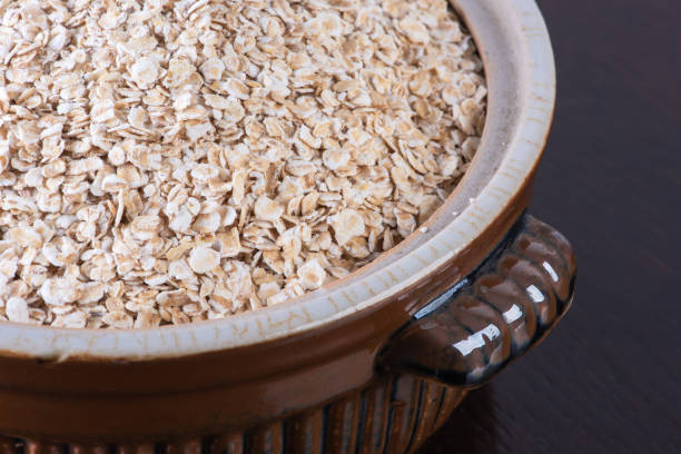 istock Oat flakes in ceramic bowl on dark 1369264416