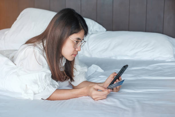 istock woman using mobile smart phone and credit card for online shopping while making order on bed in morning at home. technology, ecommerce, digital banking online payment and apartment living concept 1369266003