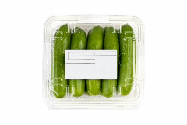 istock Freshly harvested mini cucumber with package and label on white background 1369267561