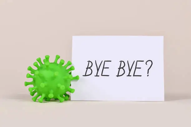 Photo of Concept for end of Corona virus pandemic with virus model and note with text 'Bye Bye?'