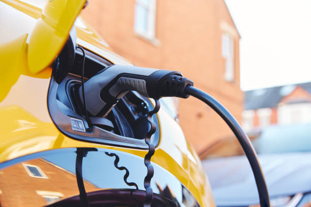 istock Electric car plugged in outside house 1369268865
