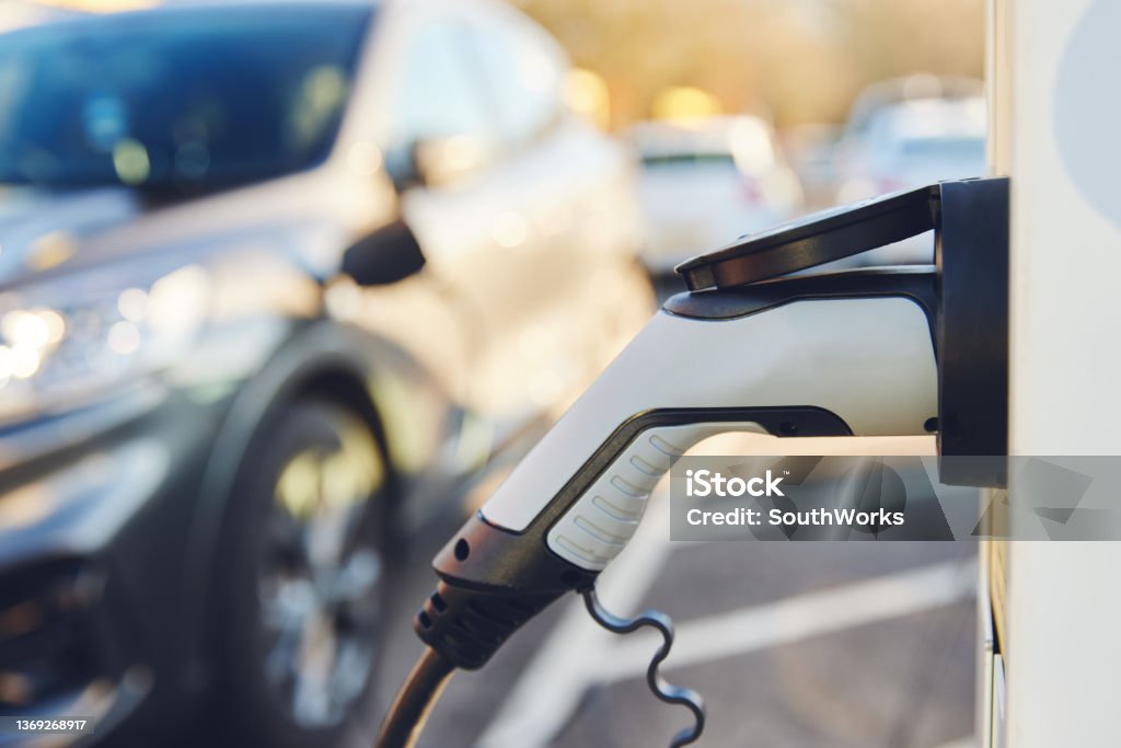 Electric Car Charging Point with copy space Electric Car Charging Point with electric car behind High Angle View Stock Photo
