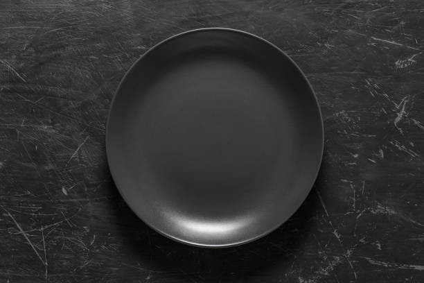 istock Grey round plate on dark background, top view. 1369269333