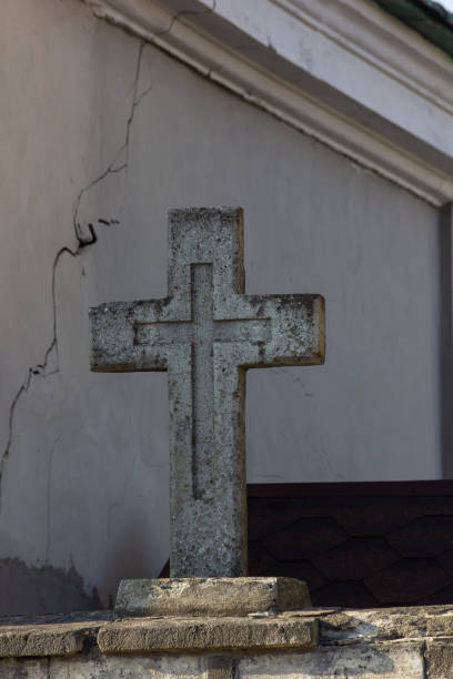 istock A gravestone with the IHS three line dollar symbol against an old stone wall with overgrowth in the foreground 1369270927
