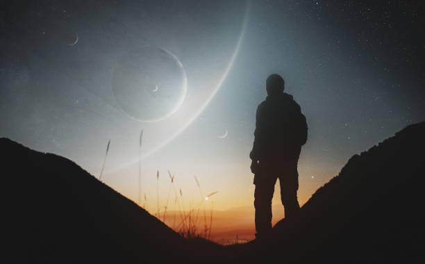 Unrecognisable person login at rising planets and stars standing in the mountains