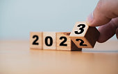 Wooden block cube flipping between 2022 to 2023 for change and preparation merry Christmas and happy new year.