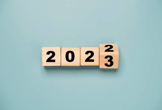 cubo di blocchi di legno che si ribalta tra il 2022 e il 2023 per il cambiamento e la preparazione buon natale e felice anno nuovo. - capodanno foto e immagini stock