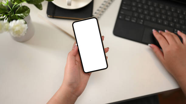 istock Female worker holding a smartphone and working on tablet 1369271879