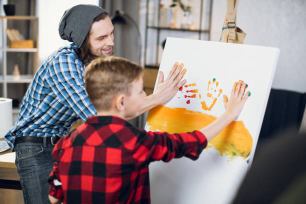 istock Father teaching little son drawing on canvas 1369272172