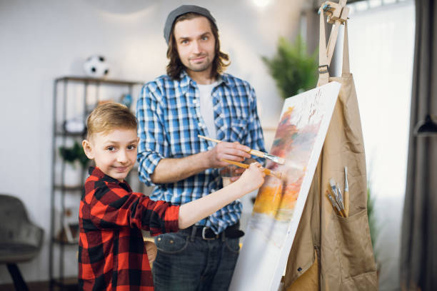 キャンバスにブラシを描いた父と息子の絵 - artists canvas indoors childhood small ストックフォトと画像
