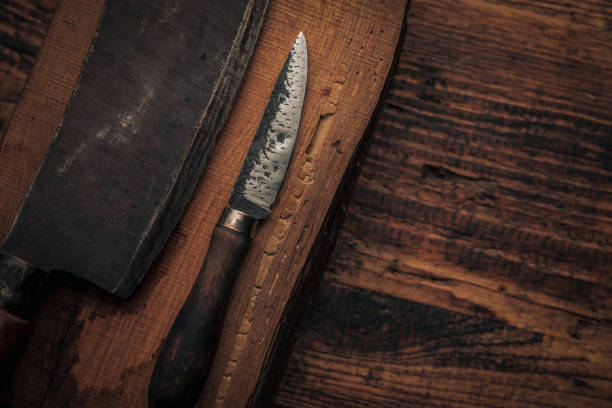istock old little utility knife next to a cleaver blade on an old cutting board 1369273387