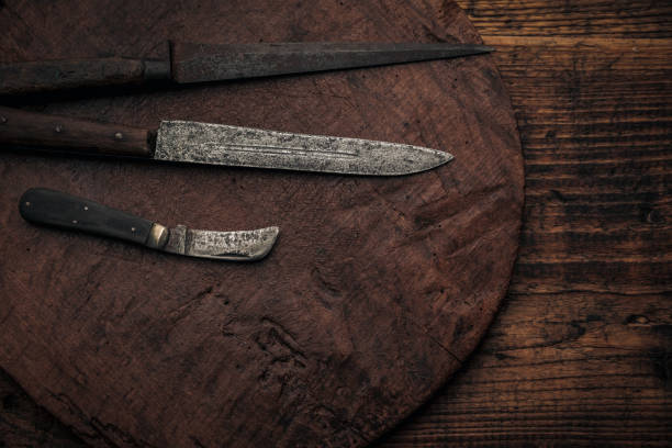 istock three different rusty vintage knives on a round old wood cutting board 1369273499