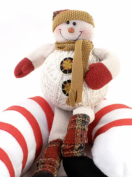 Crafted Snowman sits on giant candy-cane, with white background.