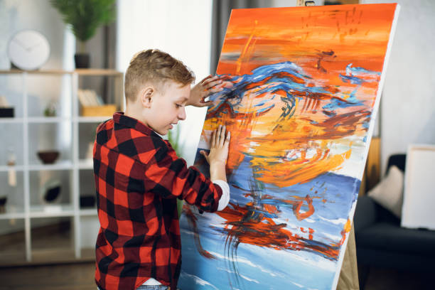 istock Inspired boy creating his masterpiece on easel with hands 1369275624