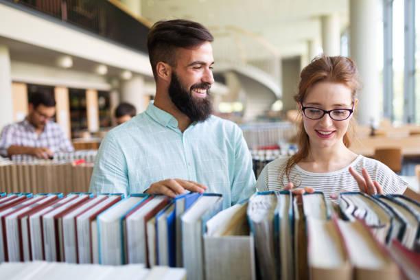 istock Students studying in library. Young success people are spending time together and learning together. 1369275904