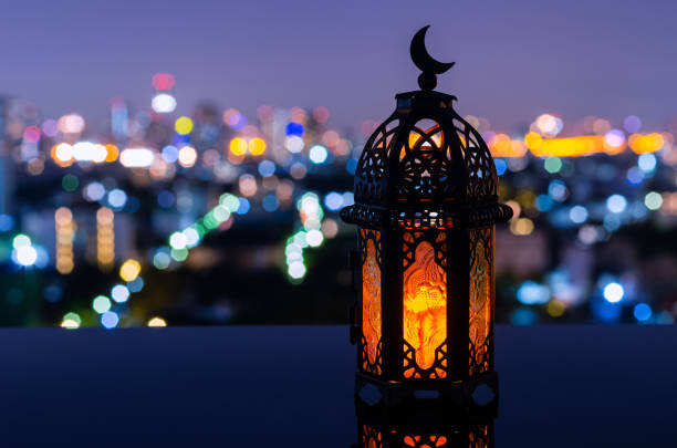 istock Lantern that have moon symbol on top with night city background 1369277788
