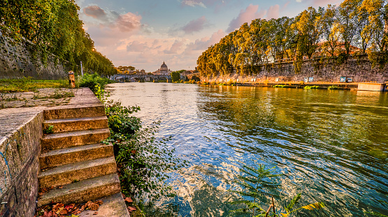 A delicate and pictorial sunset along the banks of the Tiber river in the historic and Baroque heart of Rome