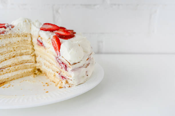 istock Delicious cake with cream cheese and strawberries. Beautiful serving on a white brick background 1369280588