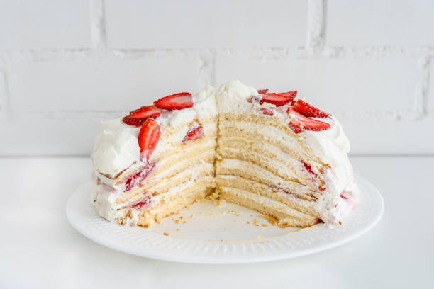 istock Delicious cake with cream cheese and strawberries. Beautiful serving on a white brick background 1369280838