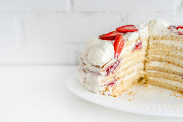 istock Delicious cake with cream cheese and strawberries. Beautiful serving on a white brick background 1369282113