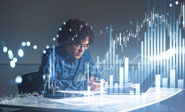 istock Businessman using phone and laptop, graph changes with rising candlesticks 1369282158
