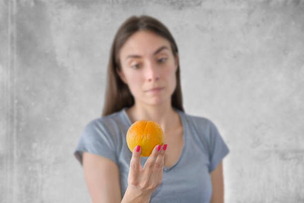 istock Young beautiful woman with orange 1369282291