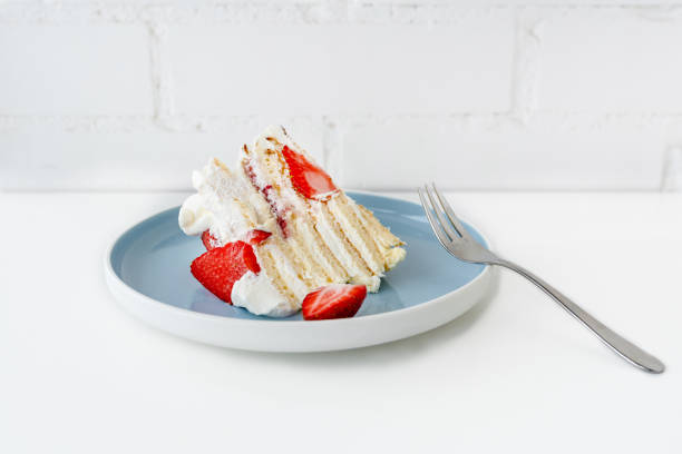 istock Light sponge cake with cream cheese and strawberries on a blue plate 1369282562