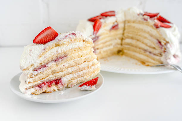 istock Delicious cake with cream cheese and strawberries. Beautiful serving on a white brick background 1369282617