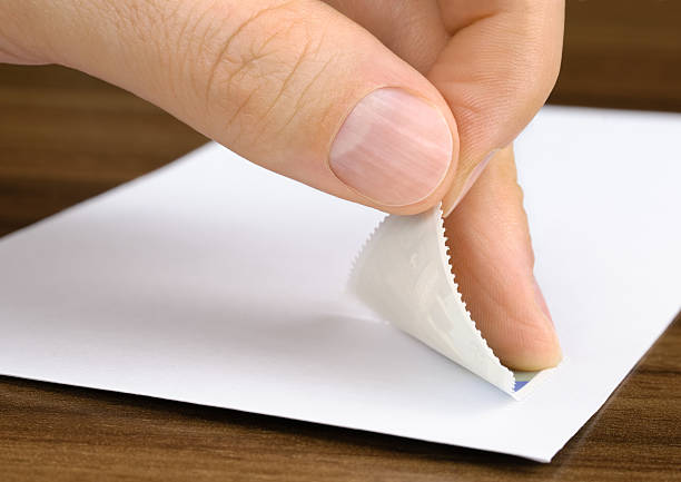 Stamp being pasted onto an envelope stock photo
