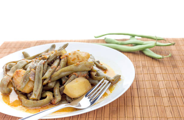 Vegetable dishes. Green beans with potatoes on a white plate close-up
