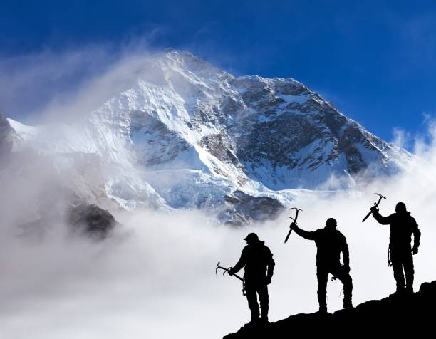 istock Mount Makalu with clouds and silhouette of three hikers 1369288870