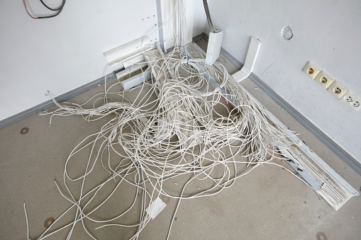 There is a pile of electrical wires on the floor.