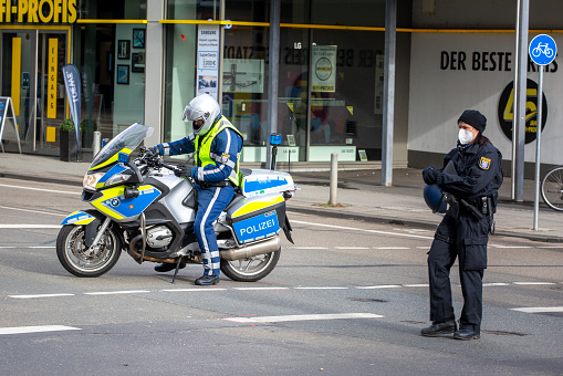 Wiesbaden, Germany - February 05, 2022: German motorbike officer safeguarding an accident scene on a busy junction in the center of Wiesbaden, Germany