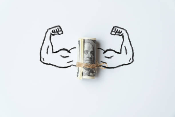 The concept of a strong world currency. Muscle hands with a bunch of us dollars money. stock photo
