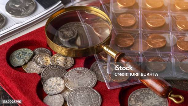 Numismatics Old Collectible Coins Made Of Silver On A Wooden Tablecoins In The Albumcollection Of Old Coins Magnifying Glass Stock Photo - Download Image Now