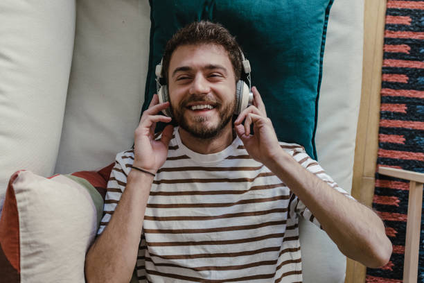 istock Happy man enjoying music at home 1369296705