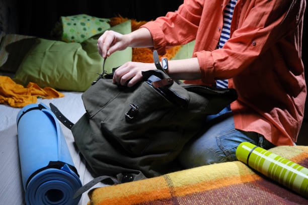 istock Mature person is packing big rucksack for hiking 1369297732