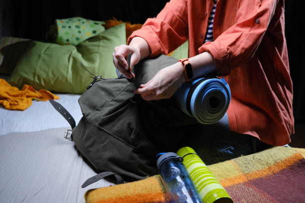 istock Mature person is packing big rucksack for hiking 1369297787