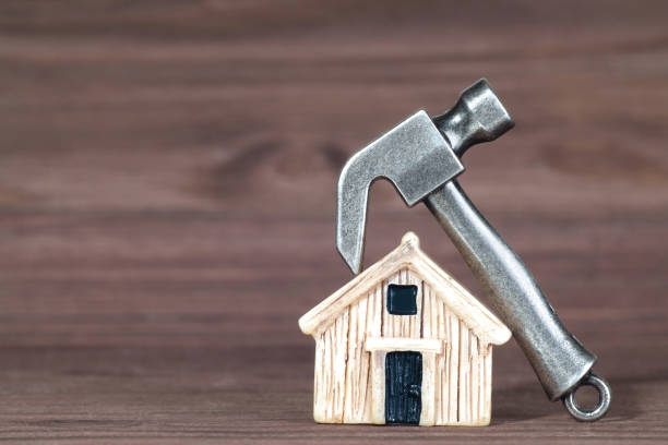 Steel hammer on a tiny wooden house