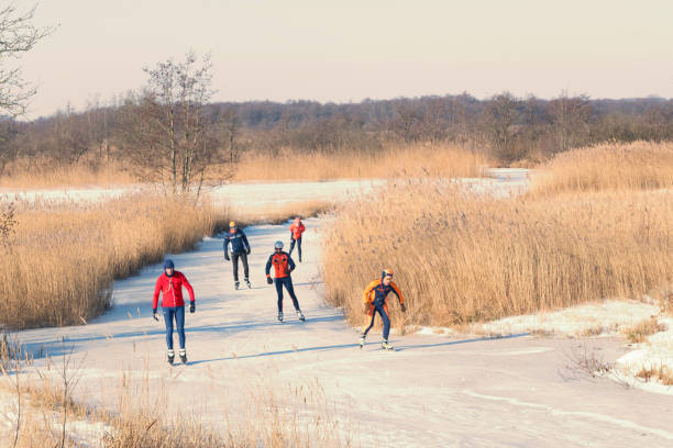 persone che pattinano sul ghiaccio nel weerribben wieden durante una bella giornata invernale - wieden weerribben foto e immagini stock