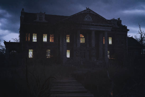 istock Abandoned creepy manor house with illuminated windows under a dark cloudy sky. 3D render. 1369299329