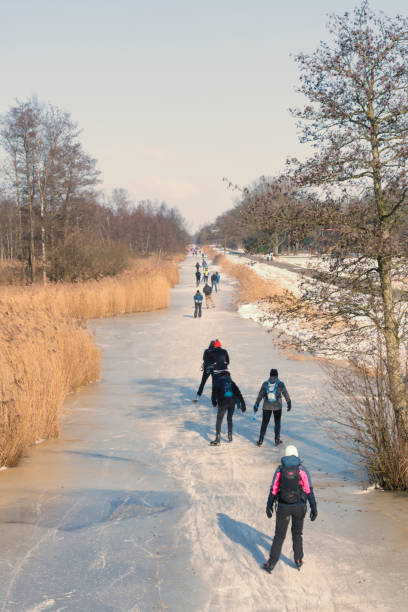 gente patinando sobre hielo en el weerribben wieden durante un hermoso día de invierno - wieden weerribben fotografías e imágenes de stock