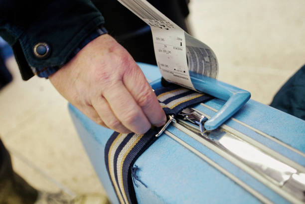 Checl-in lugage at aiport A blue suitcase is checked at airport security luggage strap stock pictures, royalty-free photos & images