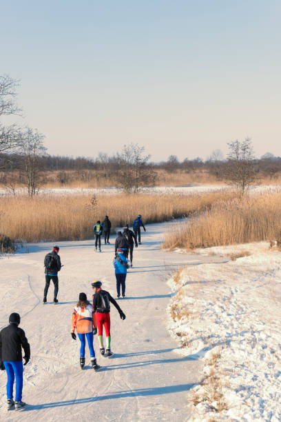 gente patinando sobre hielo en el weerribben wieden durante un hermoso día de invierno - wieden weerribben fotografías e imágenes de stock