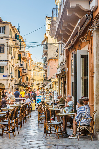 Greek taverna with people on the street between of old houses of Corfu town, Corfu, Greece