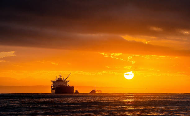 öltanker verschiffen auf see vor dem hintergrund des sonnenuntergangshimmels. öltanker im ozean. früh am morgen, der sonnenaufgang. südafrika. mossel bucht - oil tanker tanker oil sea stock-fotos und bilder