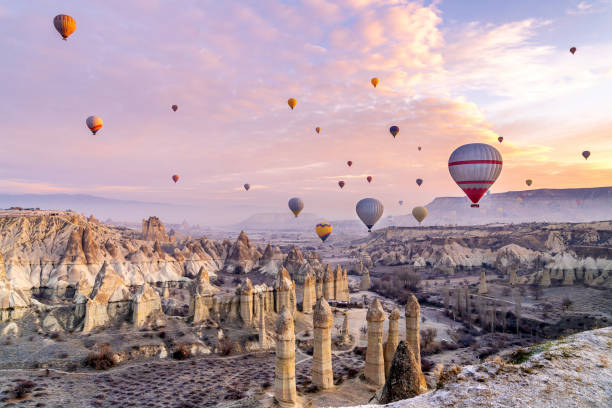 vallée de la cappadoce au lever du soleil - blowing a balloon photos et images de collection